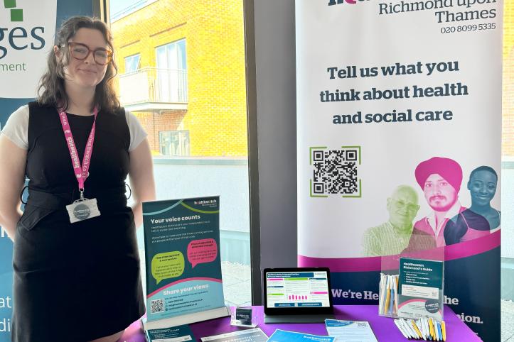 Katie stands next to a stall promoting healthwatch richmond