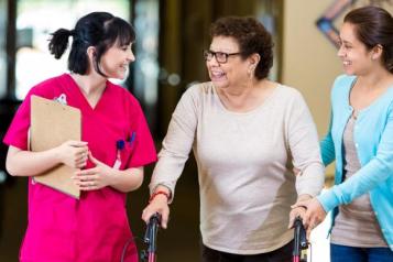 patient with mobility aid and relative talking to nurse