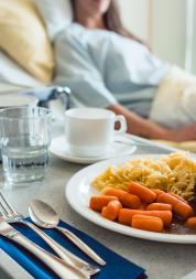 plate of food next to a hospital bed